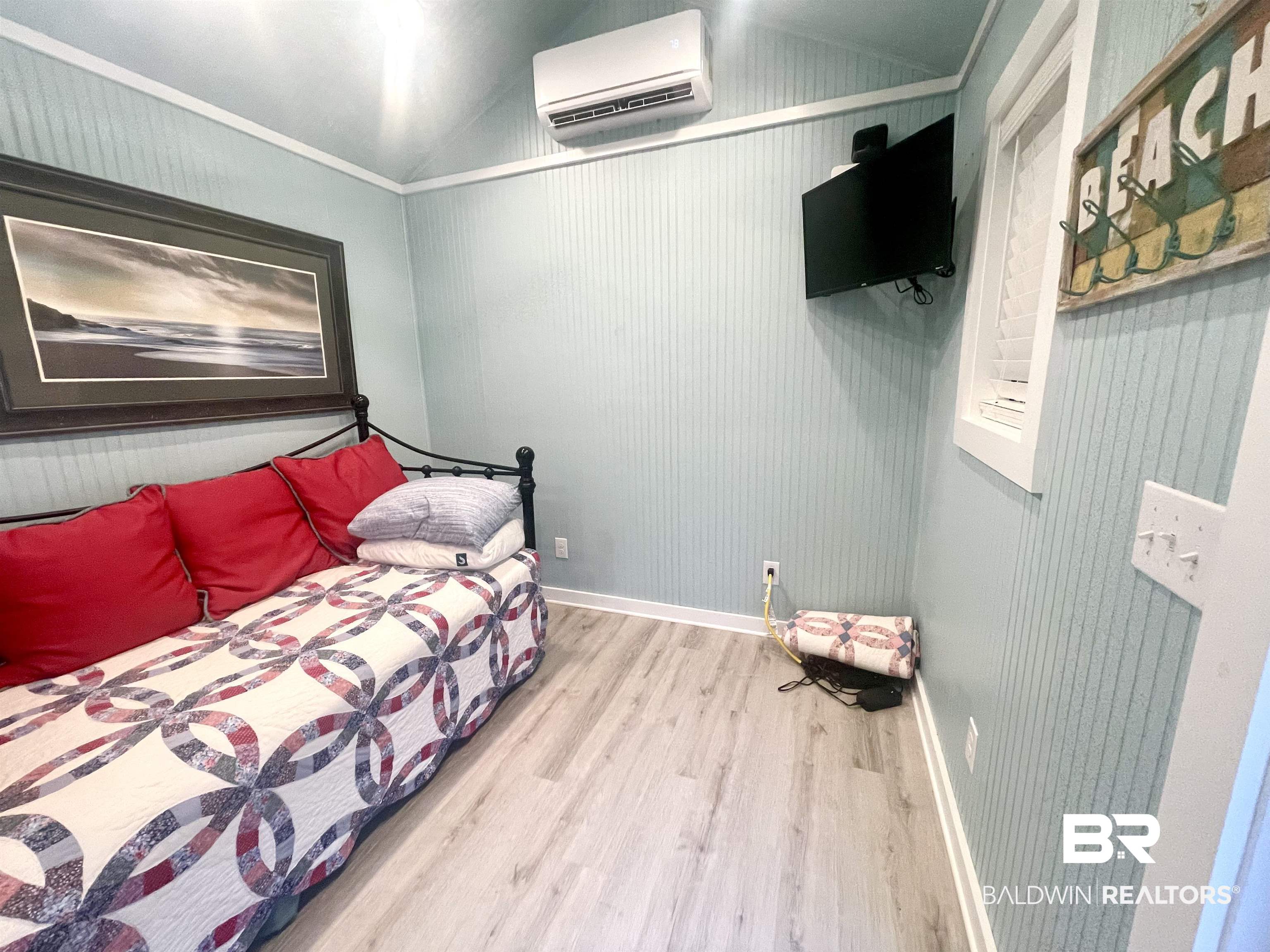 4650 Griffith Marina Road, Unit 22 Orange Beach, AL 36561 - Photo 11 of 25 Bedroom featuring a wall unit AC, wood finished floors, and vaulted ceiling