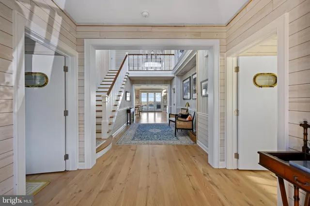 a view of a hallway with wooden floor and stairs