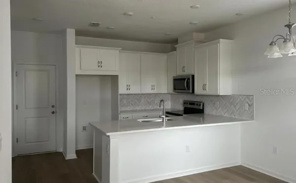 a kitchen with stainless steel appliances white cabinets and a sink