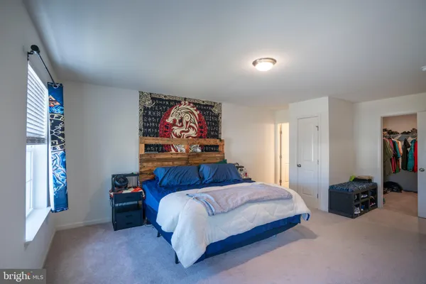 a bedroom with a bed and a painting on the wall