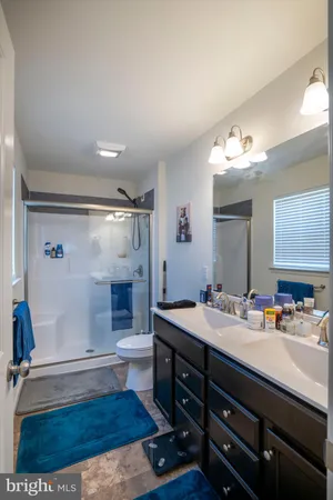 a bathroom with a sink double vanity granite and a mirror