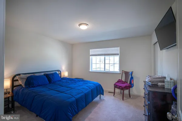 a bedroom with bed and a flat screen tv