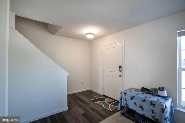 a bedroom with a small bed and wooden floor