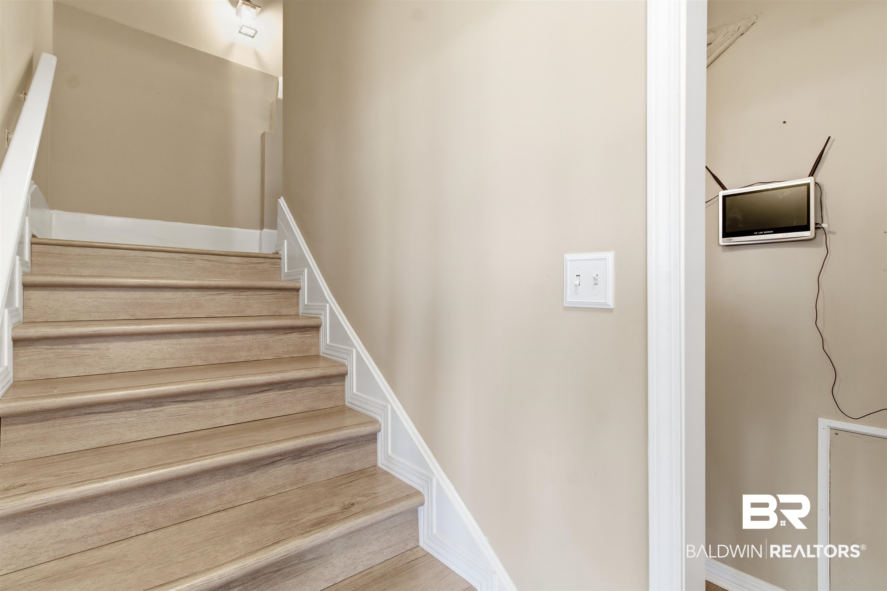 418 Veterans Road Gulf Shores, AL 36542 - Photo 21 of 51 Stairway featuring baseboards and wood finished floors