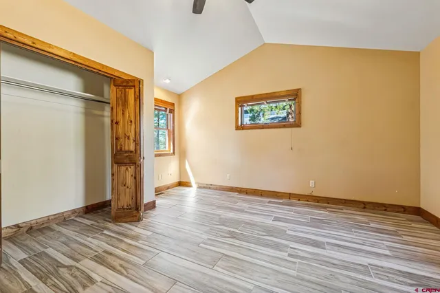 an empty room with ceiling fan and window