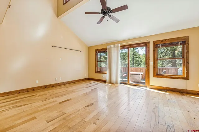 a view of a room with kitchen island stainless steel appliances wooden floor windows and a chandelier