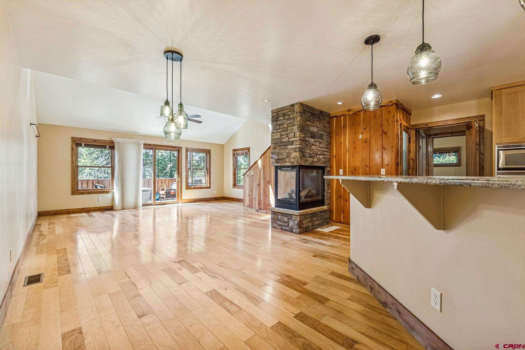 157 Window Lake Trail Durango, CO 81301 - Photo 8 of 39 a view of a room with kitchen island stainless steel appliances wooden floor windows and a chandelier