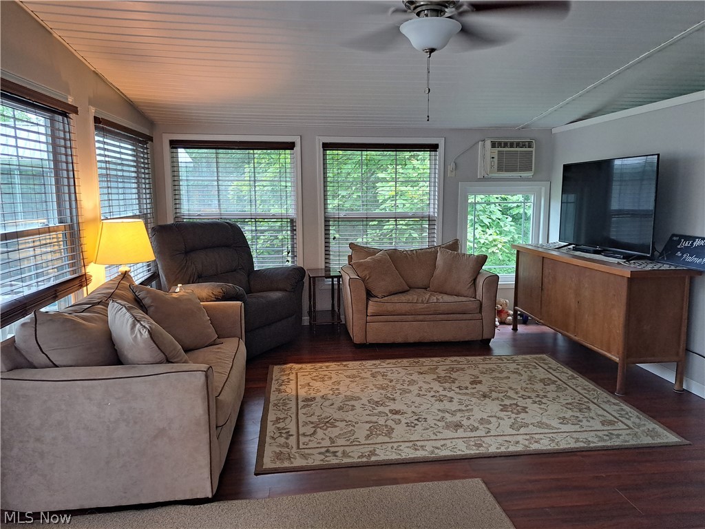 17875 Lashley Road, Unit 124 Senecaville, OH 43780 - Photo 15 of 45 Living room with a wall mounted air conditioner, ceiling fan, plenty of natural light, dark hardwood / wood-style floors, and lofted ceiling