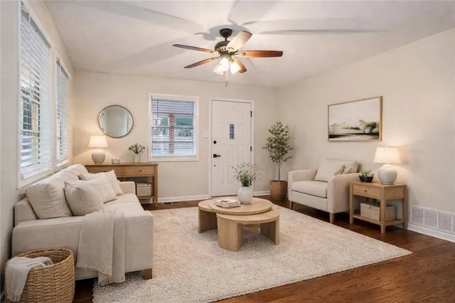 a living room with furniture a rug and a window