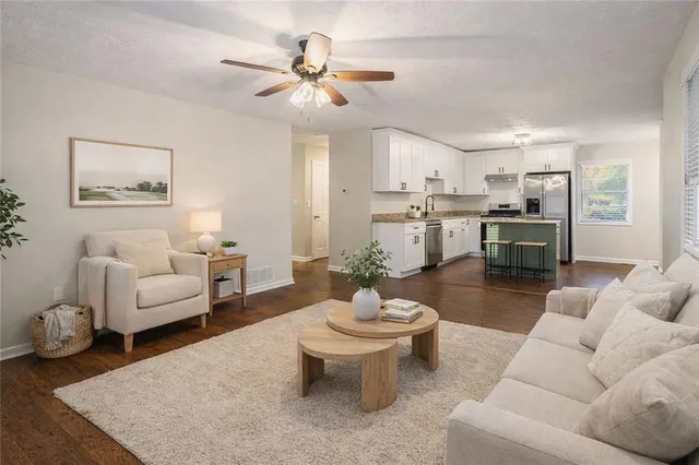 a living room with furniture and view of kitchen