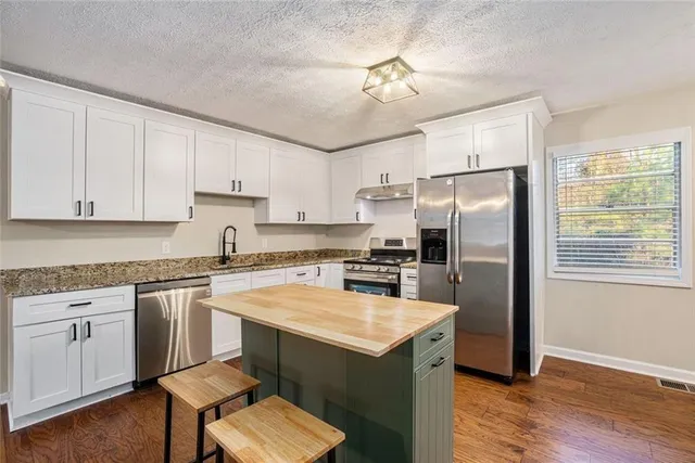 a kitchen with cabinets appliances and a center island