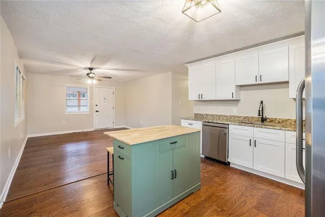 a kitchen with granite countertop white cabinets and white appliances