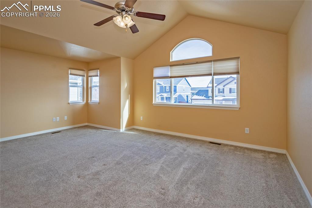 7160 Red Cardinal Loop Colorado Springs, CO 80908 - Photo 32 of 49 an empty room with a chandelier fan and windows