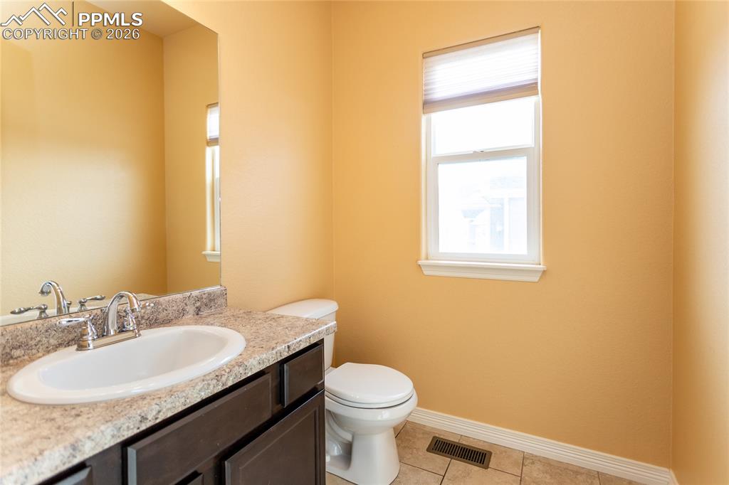 7160 Red Cardinal Loop Colorado Springs, CO 80908 - Photo 33 of 49 a bathroom with a granite countertop sink toilet and a mirror