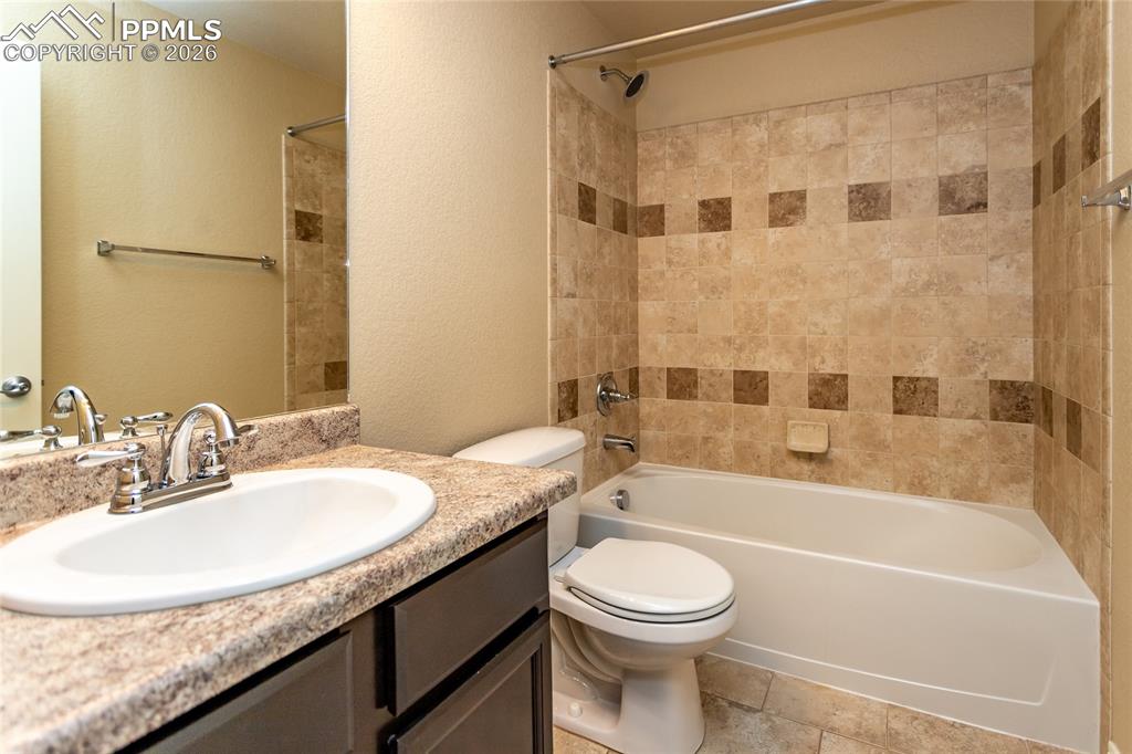 7160 Red Cardinal Loop Colorado Springs, CO 80908 - Photo 36 of 49 a bathroom with a granite countertop bathtub sink vanity mirror and toilet
