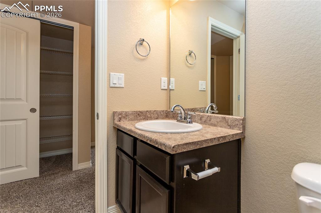 7160 Red Cardinal Loop Colorado Springs, CO 80908 - Photo 37 of 49 a bathroom with a granite countertop sink and a mirror