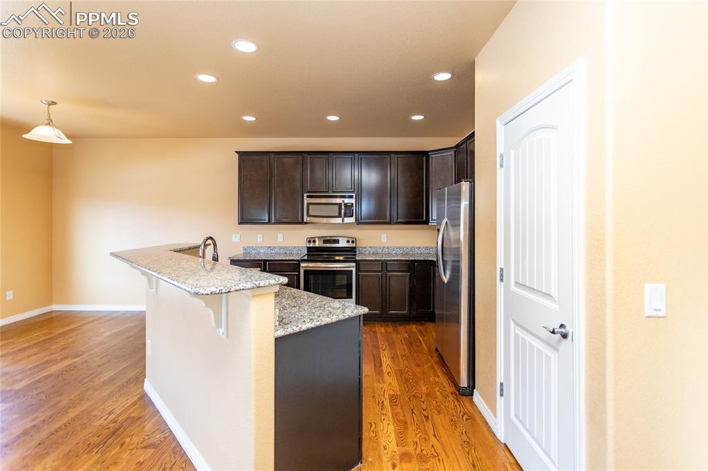 7160 Red Cardinal Loop Colorado Springs, CO 80908 - Photo 6 of 49 a kitchen with a sink a counter top space stainless steel appliances and cabinets