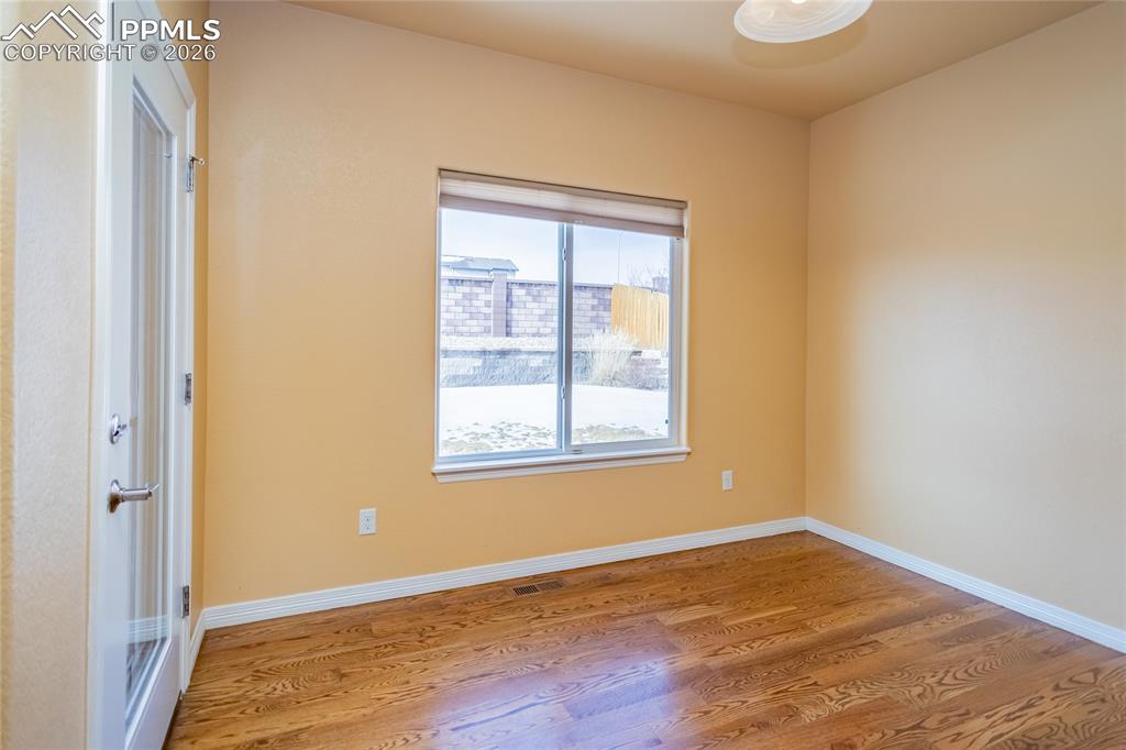 7160 Red Cardinal Loop Colorado Springs, CO 80908 - Photo 8 of 49 an empty room with wooden floor and windows