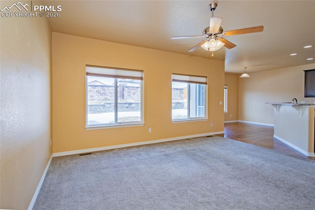 7160 Red Cardinal Loop Colorado Springs, CO 80908 - Photo 10 of 49 a view of an empty room with chandelier fan and fire place