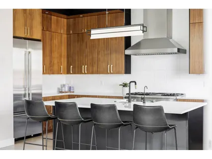 a kitchen with a dining table chairs and a refrigerator