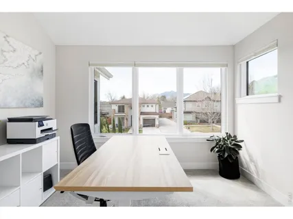 a hallway with painting on the wall and a potted plants