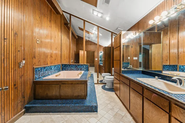 a bathroom with a tub a sink and mirror