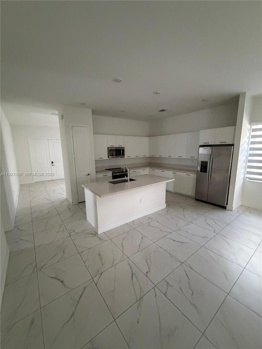 4321 Southwest 173rd Avenue Miramar, FL 33029 - Photo 6 of 28 a kitchen with cabinets and white appliances