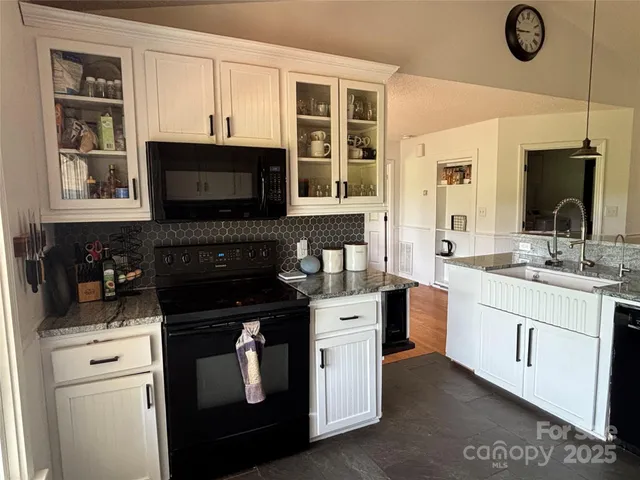 a kitchen with stainless steel appliances granite countertop a stove a sink and a microwave