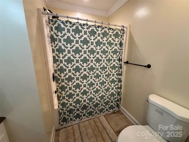 a white toilet sitting next to a shower curtain