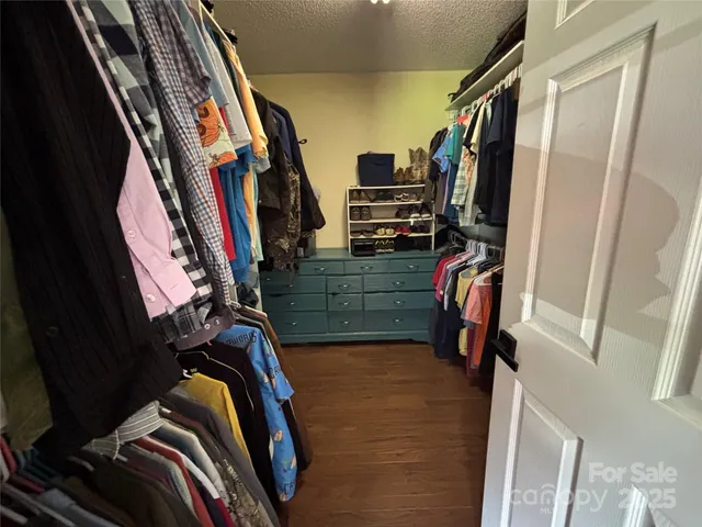 a view of walk in closet with clothes