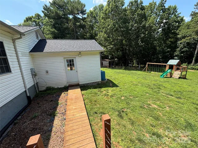 a view of a backyard with table and chairs and wooden fence