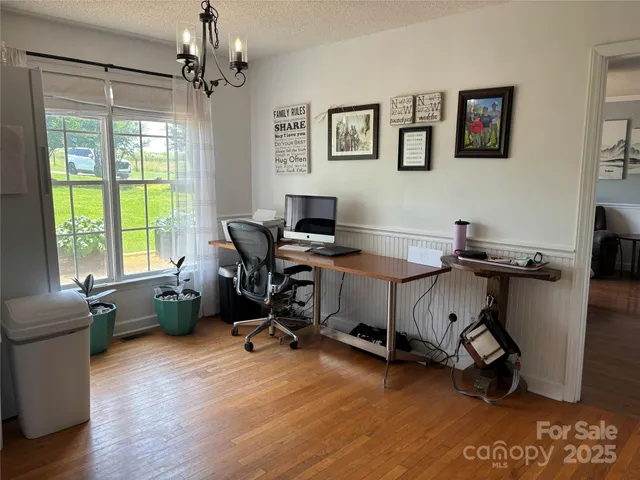 a view of a workspace with furniture and a window