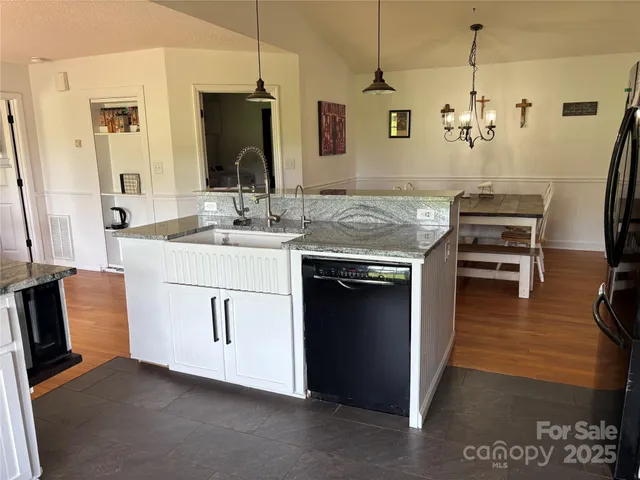 a kitchen with a sink stove and wooden floor
