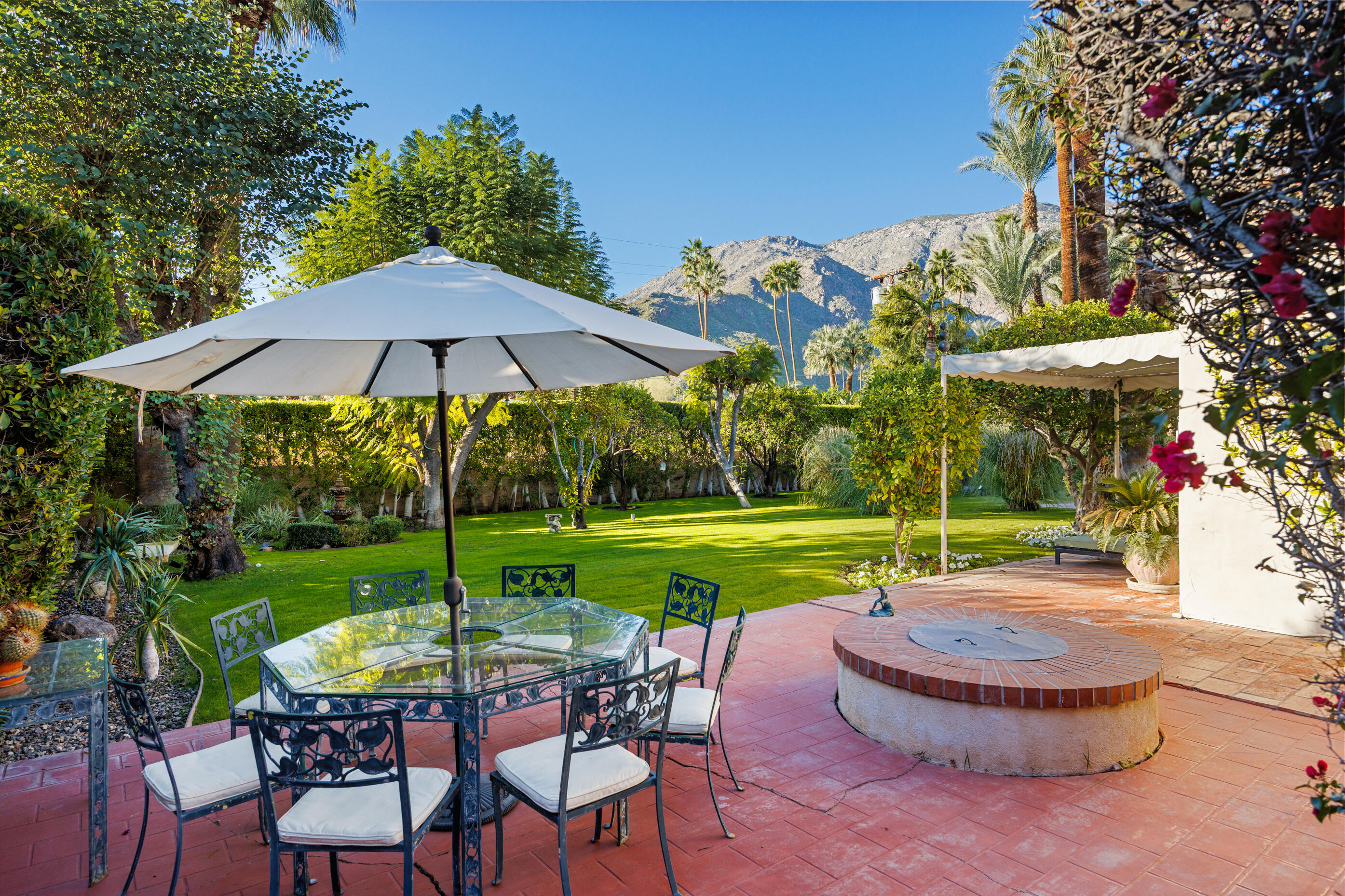 1050 North Cahuilla Road Palm Springs, CA 92262 - Photo 11 of 32 a view of a backyard with table and chairs under an umbrella