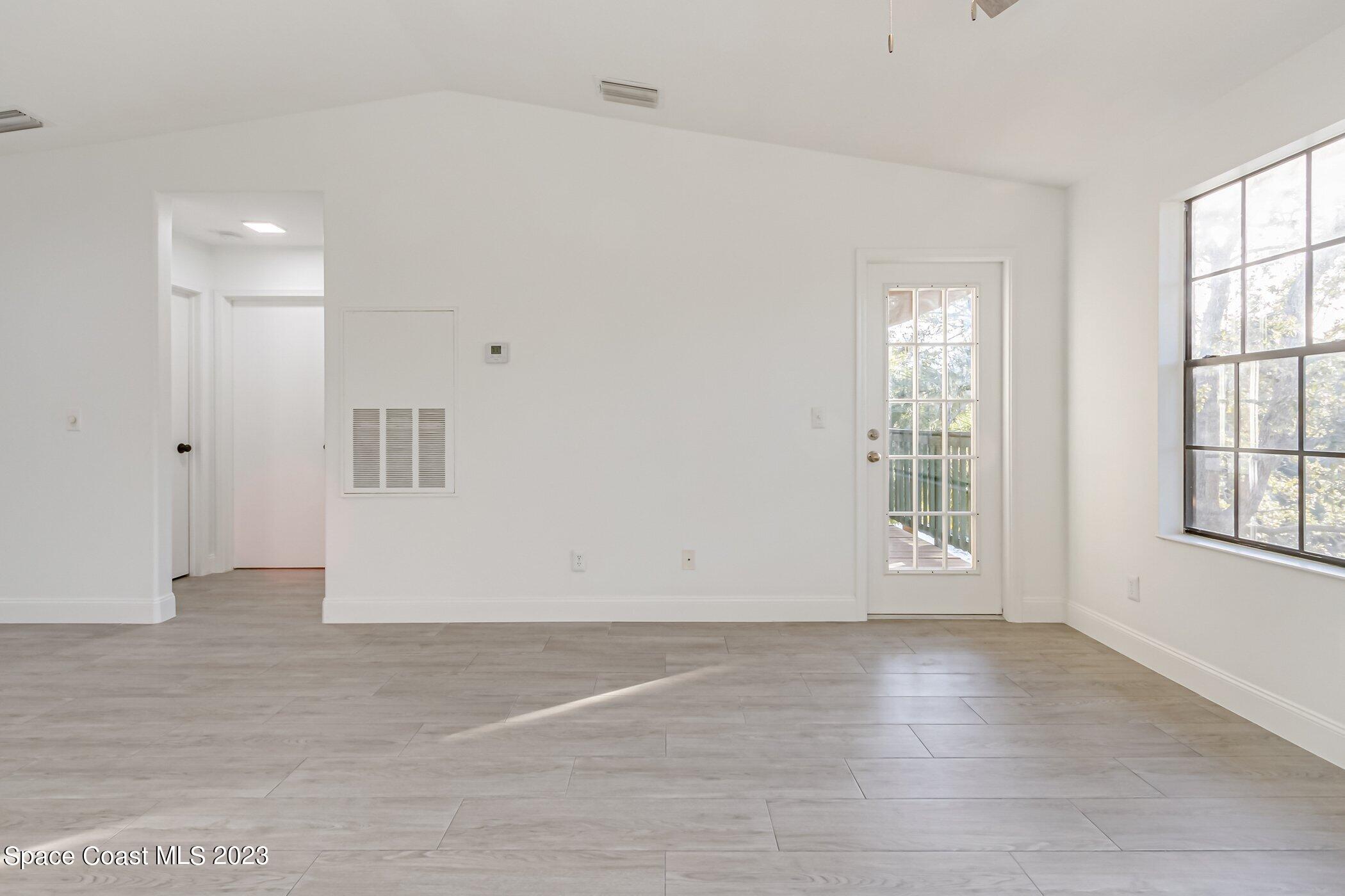 7667 North Wickham Road, Unit 218 Melbourne, FL 32940 - Photo 15 of 35 an empty room with wooden floor and windows