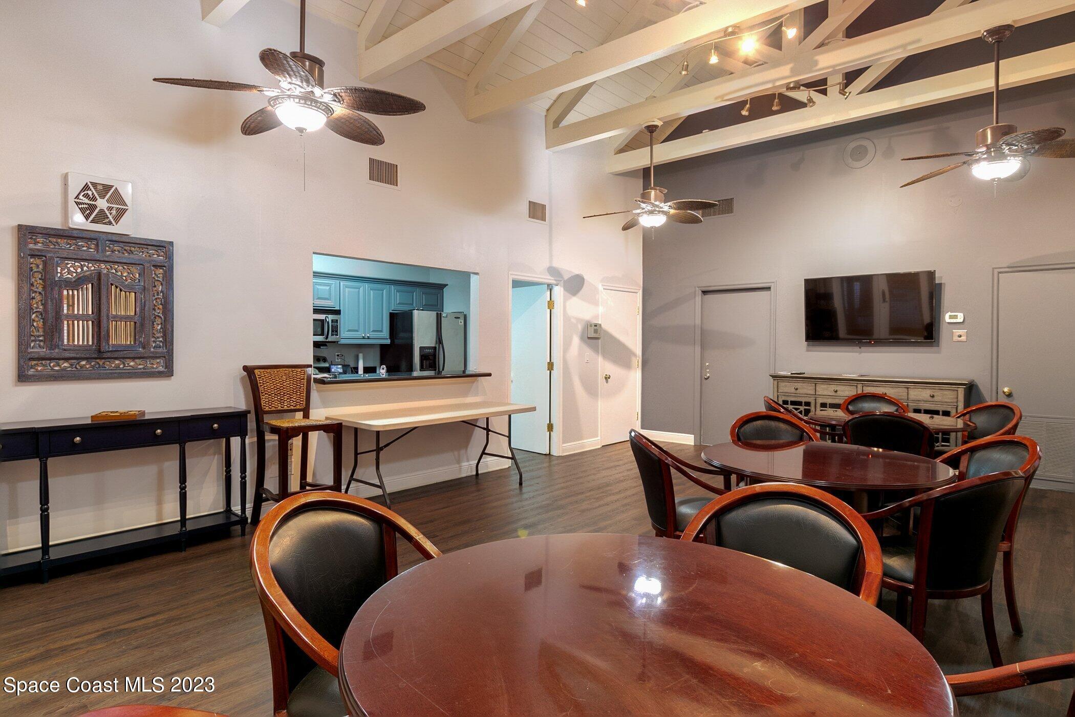 7667 North Wickham Road, Unit 218 Melbourne, FL 32940 - Photo 27 of 35 a living room with furniture a flat screen tv and kitchen view