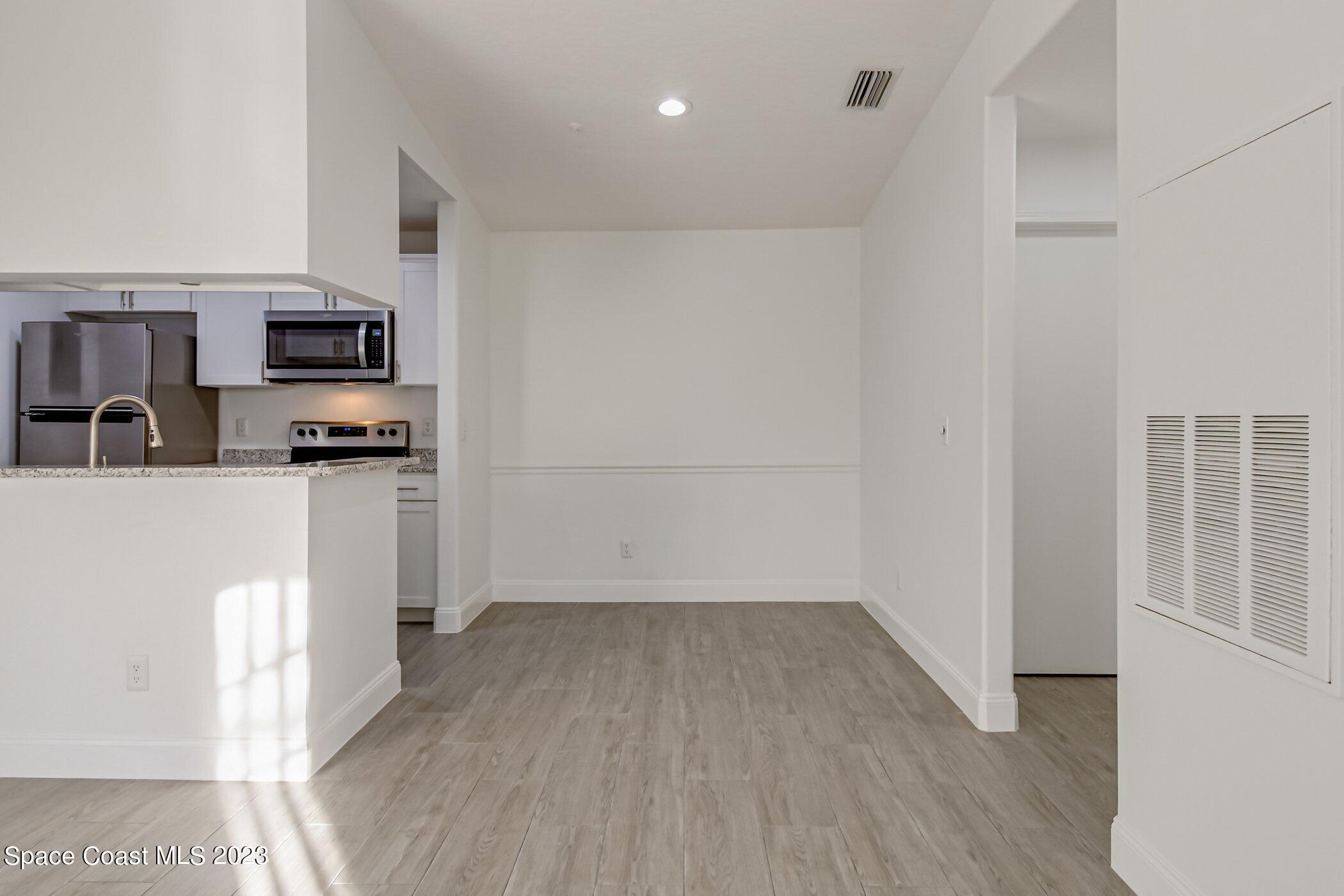 7667 North Wickham Road, Unit 218 Melbourne, FL 32940 - Photo 4 of 35 a view of a kitchen with a sink and a refrigerator