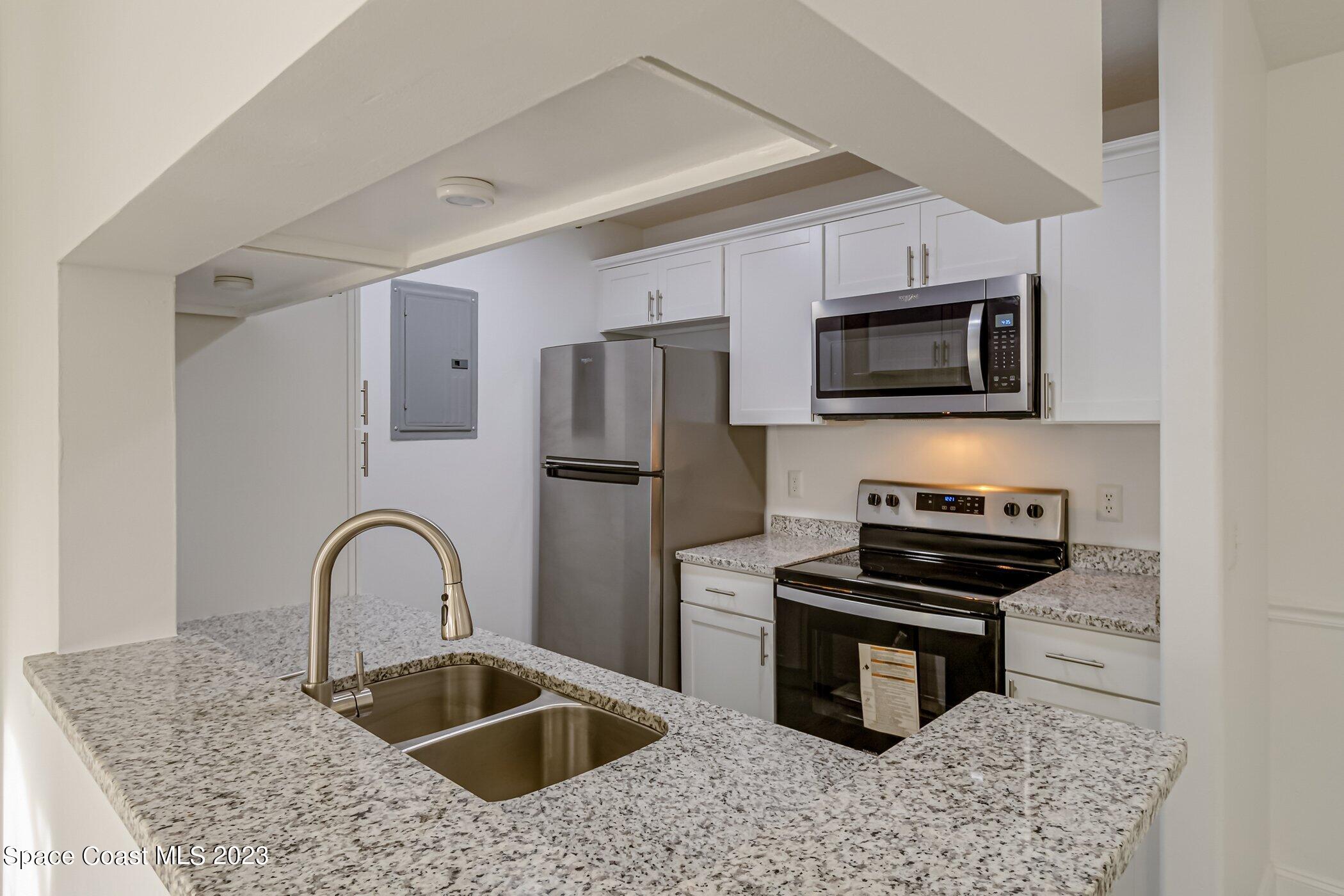 7667 North Wickham Road, Unit 218 Melbourne, FL 32940 - Photo 5 of 35 a kitchen with a sink cabinets and stainless steel appliances