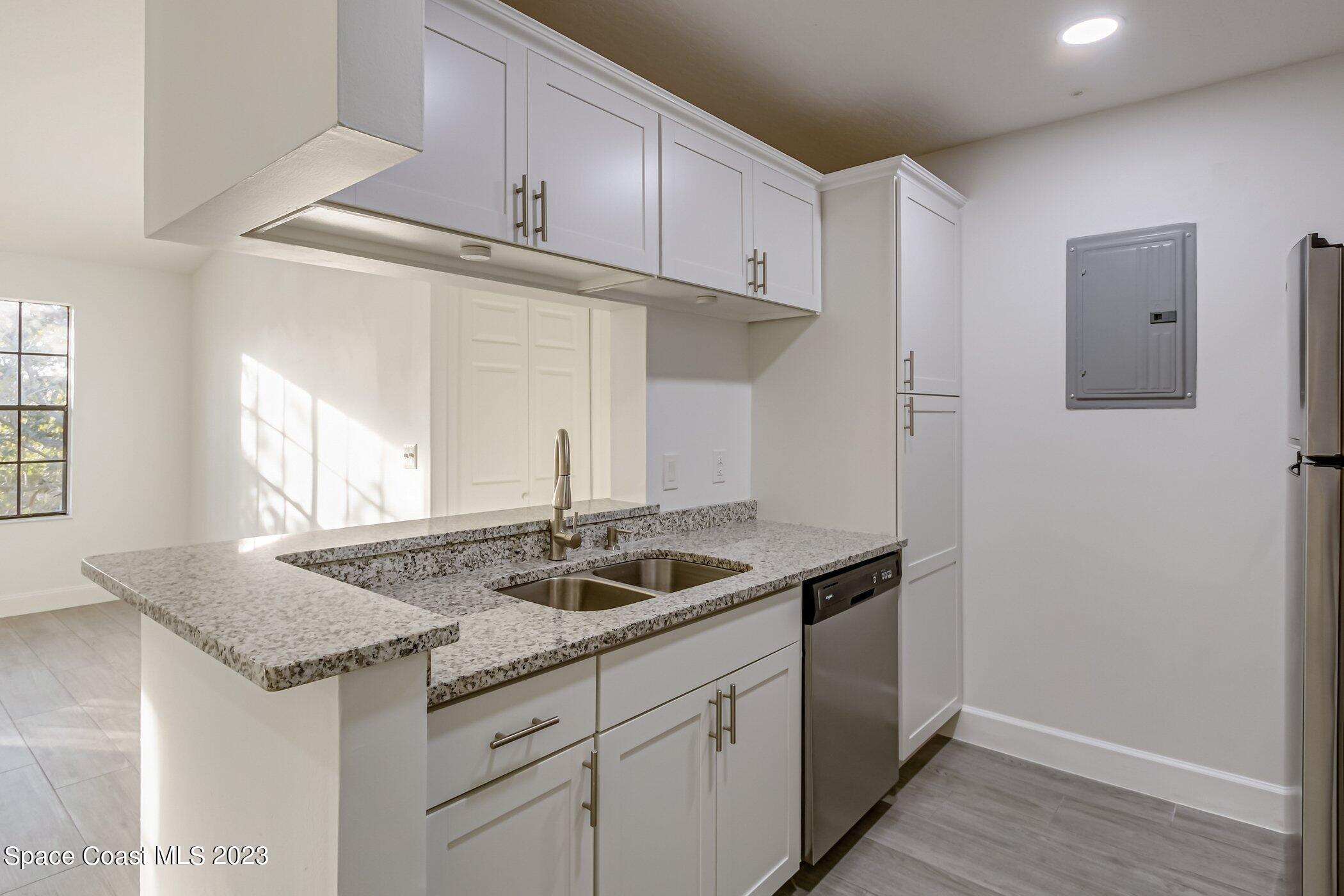 7667 North Wickham Road, Unit 218 Melbourne, FL 32940 - Photo 6 of 35 a kitchen with granite countertop a sink and cabinets