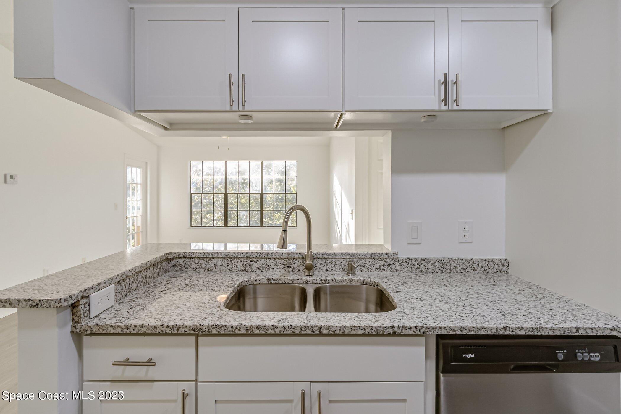 7667 North Wickham Road, Unit 218 Melbourne, FL 32940 - Photo 8 of 35 a kitchen with granite countertop a sink and a granite counter tops
