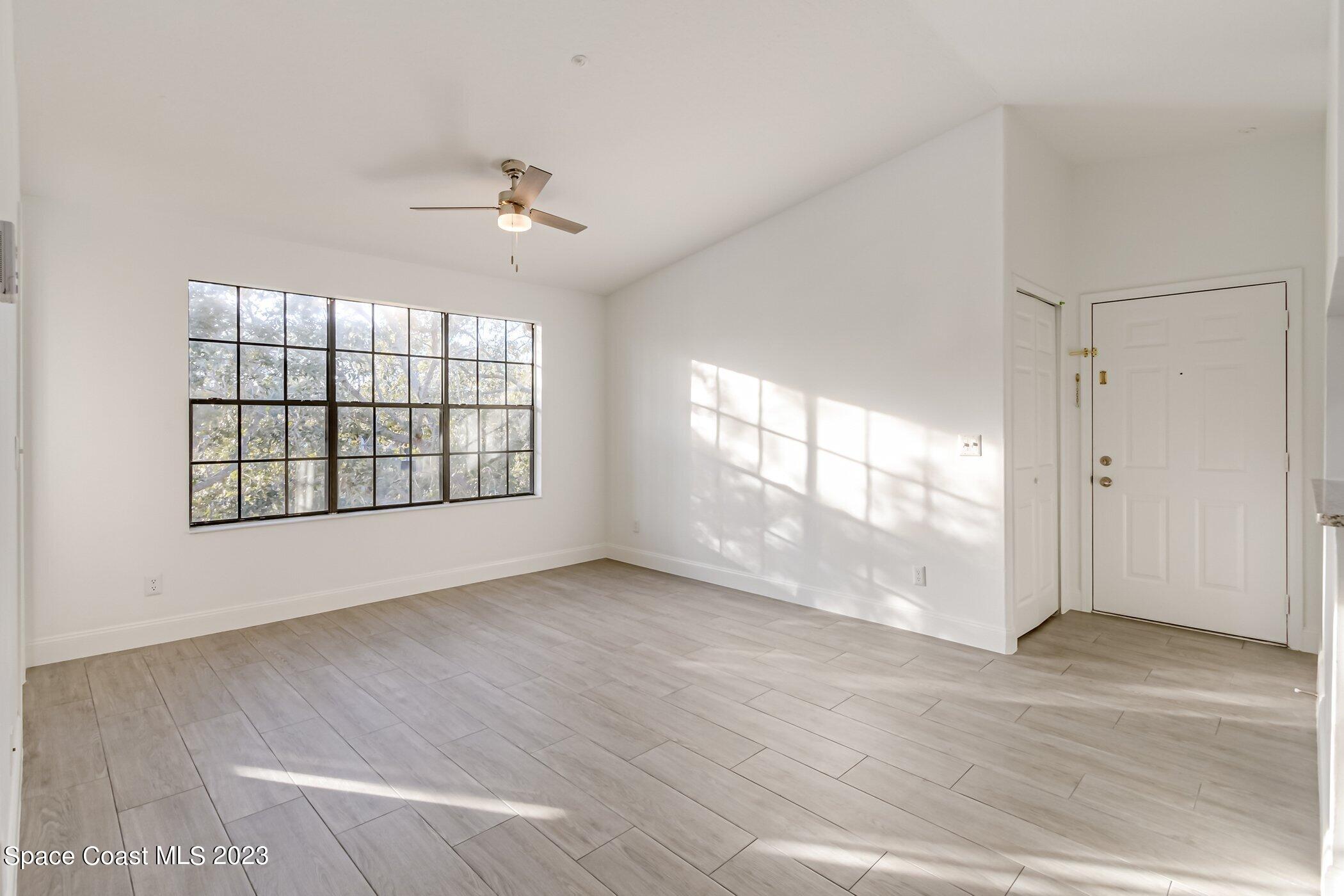 7667 North Wickham Road, Unit 218 Melbourne, FL 32940 - Photo 9 of 35 wooden floor in an empty room with a window