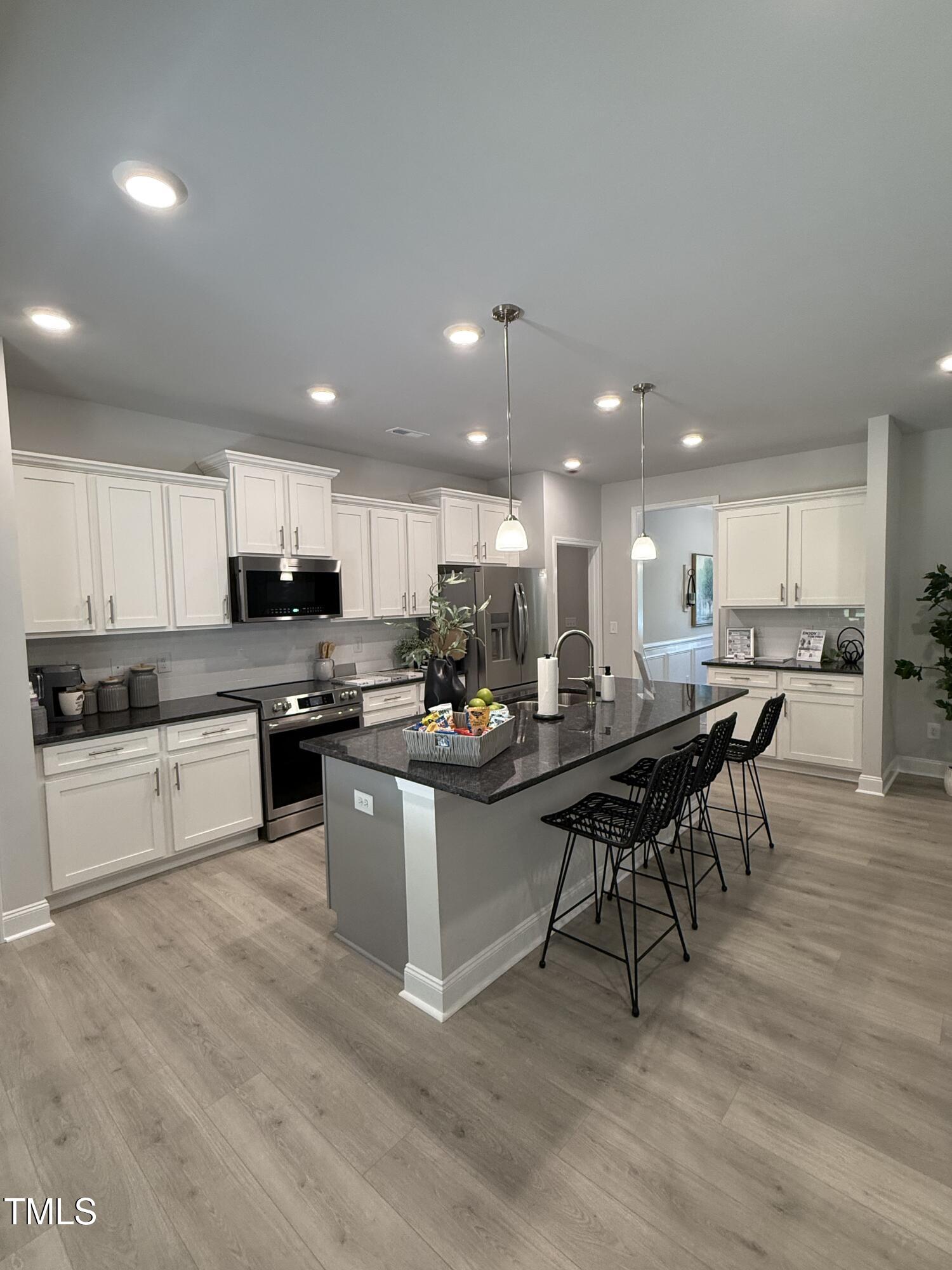 30 Lemon Drop Lane Louisburg, NC 27549 - Photo 10 of 21 a kitchen with a sink dining table wooden floor and view living room