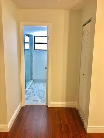 an empty room with wooden floor and closet