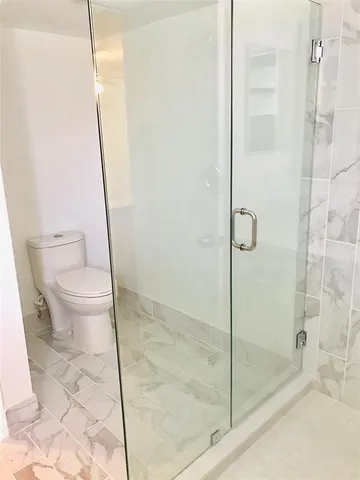 a bathroom with a toilet and a shower