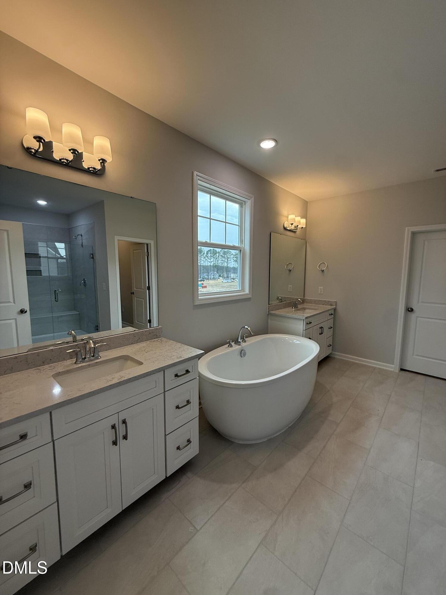 2429 Picual Way Apex, NC 27502 - Photo 12 of 21 a bathroom with a bathtub sink and mirror