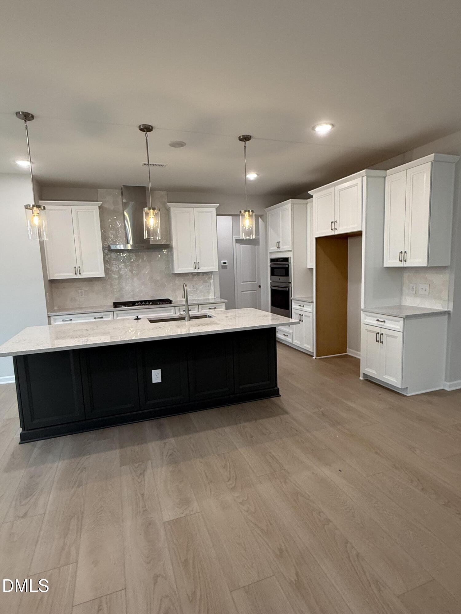 2429 Picual Way Apex, NC 27502 - Photo 4 of 21 a large kitchen with a large counter top stainless steel appliances and cabinets