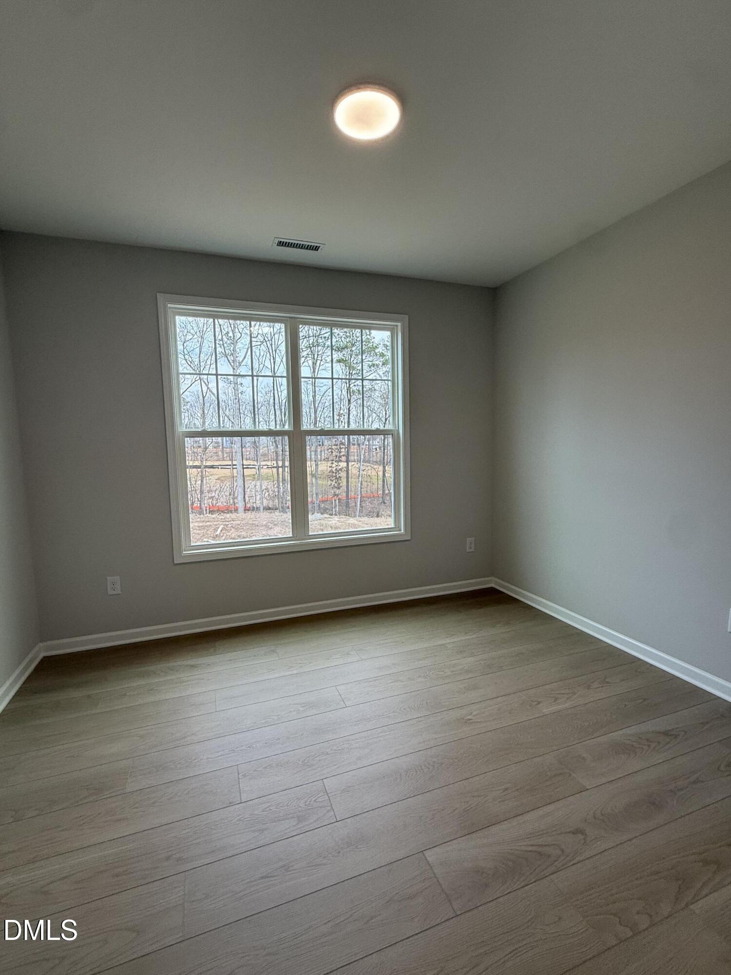 2429 Picual Way Apex, NC 27502 - Photo 7 of 21 an empty room with wooden floor and windows