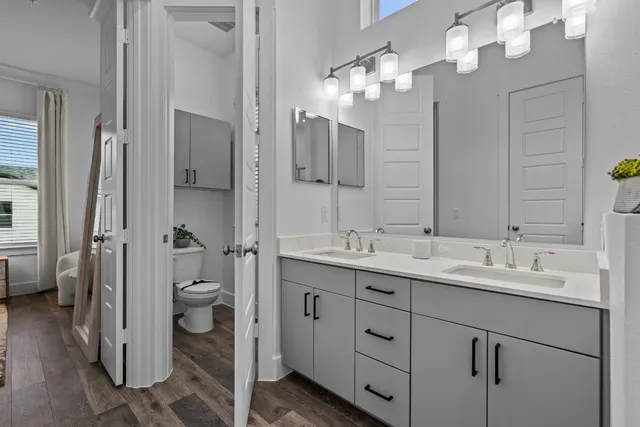 a spacious bathroom with a double vanity sink a mirror and a shower