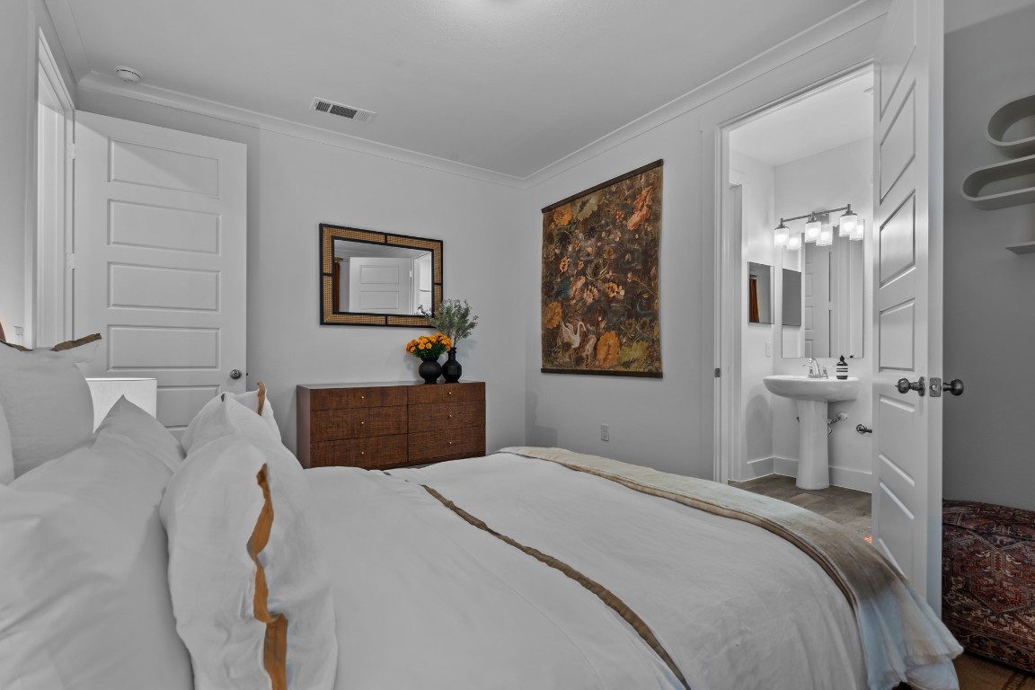 1664 Hillside Terrace, Unit 2117 Buda, TX 78610 - Photo 18 of 33 a bedroom with a bed and a chandelier