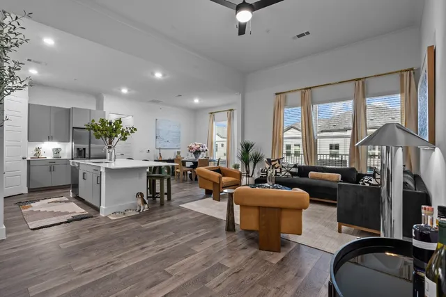 a view of a dining room with furniture a kitchen and chandelier